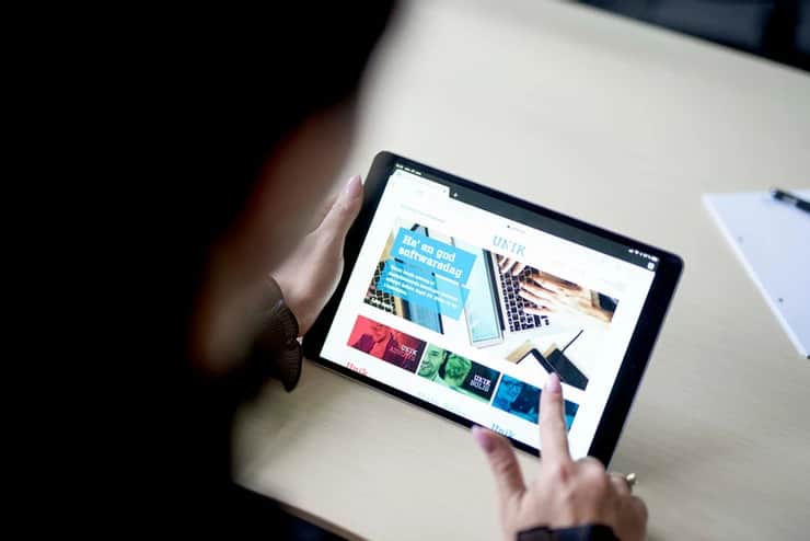 Providing property managers in Denmark a smarter way to run general meetings – Assembly Voting Someone using a tablet to browse Unik System Designs website