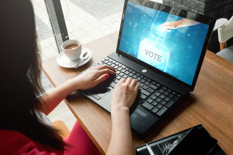 A woman votes via her laptop computer, similar to Electa.